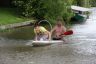 De start was per surfplank, waarop 2 personen plaats hadden genomen vlak achter de brug over de opvaart. De voorste persoon moest door een hoepel kruipen tijdens het varen en aan een aan de brug opgehangen bel trekken. Dat was het sein voor een ploeggenoot om in een in het water liggende autoband te springen, waarna hij/zij aan een touw naar het ponton werden getrokken. daarna sprietlopen over een ronde balk vanaf het ponton naar de wal. Wie hiermee de snelste maakte was winnaar. Maar..... het ging niet altijd goed, kijk maar.  