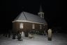 Ook de kerk in het dorp krijgt een deel van het pak sneeuw op zijn dak.