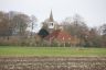 Boerderij en kerk in lichte nevel.