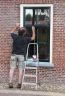 Een andere dorpsbewoner verft zijn ramen van zijn woning aan de Hege Wier.