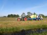 Een tractor met balenpers van loonbedrijf Wierda in actie op het land van J.Buter aan de Hege Wier bij Goënga.