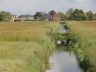 Dam met dubbele duiker op het land van R. de Jong. p de achtergrond het dorp Goënga.