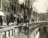 1930. De Singel word vanaf de Looxmagracht tot aan de Doopsgezinde kerk overkluisd, te zien aan de ingeheide palen. Dit gebeurede met een zogenaamde Hollandse stelling, waarvan de houten heiblokgeleiders met touwen werden 'getuid', ofwel staande gehouden.
Let op de paal met de klimblokken, het werd gebruikt als het touw van het heiblok van de katrol bovenin de stelling er afliep.