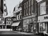 In de Nauwe Burgstraat zien we rechts de winkel van P(iet) de Gruyter. De echte naam was De Gruiter, maar voor de winkel werd uit commercieel belang de Griekse Y ingevoerd. P. de Gruyter was in Den Bosch begonnen met zijn handel. De winkel in Sneek bestond van 1920 tot 1976.
De slogan van de Gruyter was: En betere waar en 10 %.