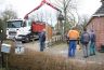 Het onderste deel van de stam wordt door Jan de Groot afgezaagd, terwijl de onontbeerlijke toeschouwers het tafereel gadeslaan.