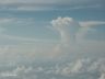 Omhoog getuwde wolk boven de oceaan. Foto vanuit het raam van het vliegtuig.