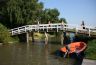 De dappersten springen vanaf de brug in het water, anderen kijken nog even toe.