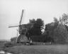 Op de foto de vroegere molen achter de boerderij van de familie van der Wier Alberda. Bij de molen staat in witte broek, Pieter Boomstra, zijn moeder was Antje van der Wier en getrouwd met een Boomstra, een geslacht van aannemers en architecten uit Goënga.